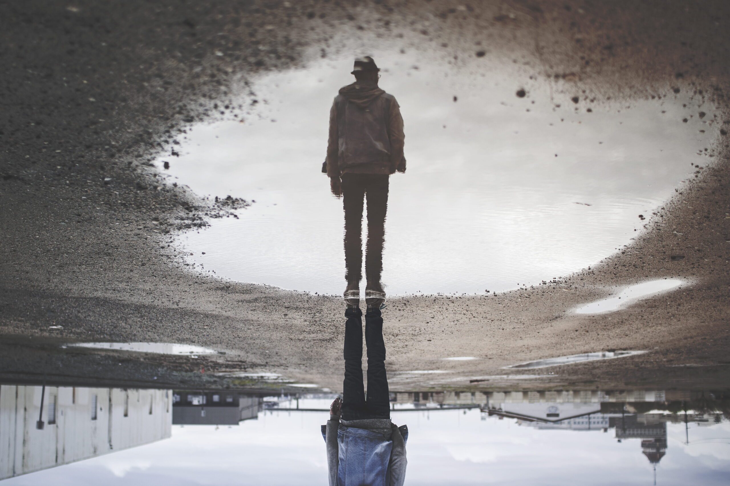 Upside down reflection in a puddle of a man standing
