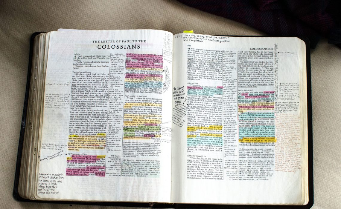 Bible laying open on the book of Colossians with verses highlighted and notes made in the margin.